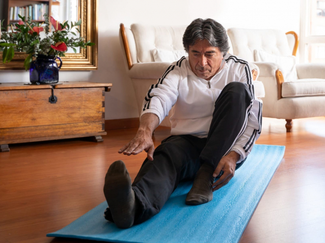 Adult-man-exercising-at-home-and-stretching-his-legs-1265265480_6233x3938